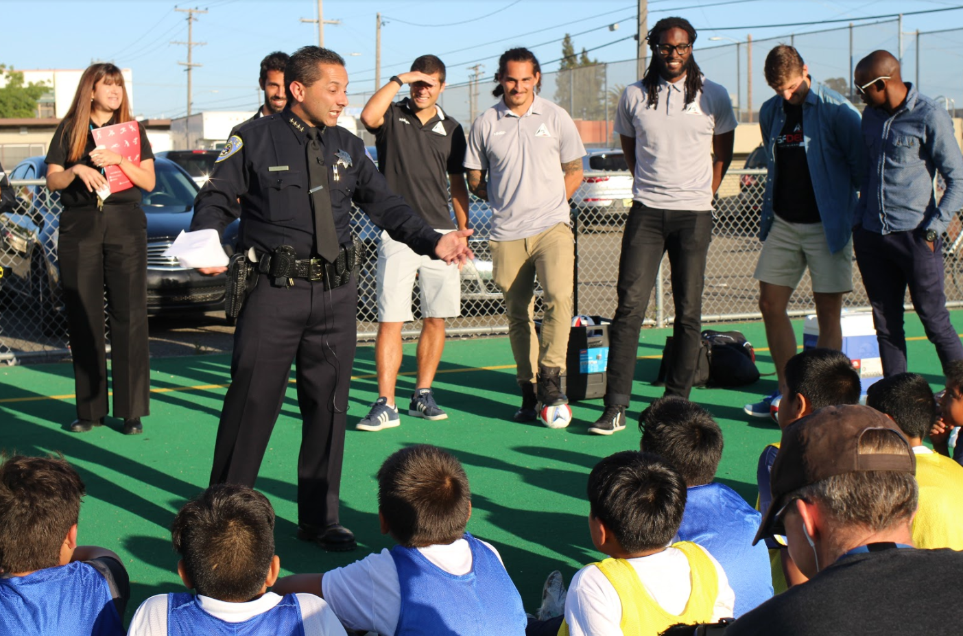 BART Police Chief Carlos Rojas visits with Leopards players at a practice